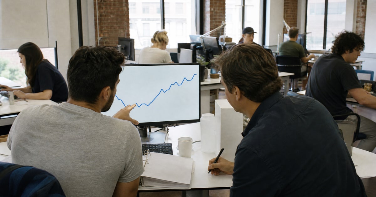 Flapen cover for Compare Amazon PPC vs full-service agencies: a Flapen operator showing a client a sales chart beside an open proposal binder