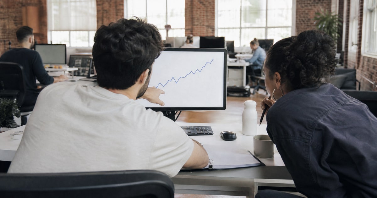 Flapen cover for Contract terms to negotiate with Amazon agencies: a Flapen operator showing a client a sales chart beside an open proposal binder