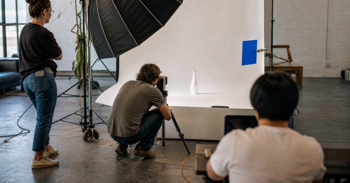 Flapen cover for Fair Amazon agency pricing models: a client watching the Flapen photographer frame a product in the studio