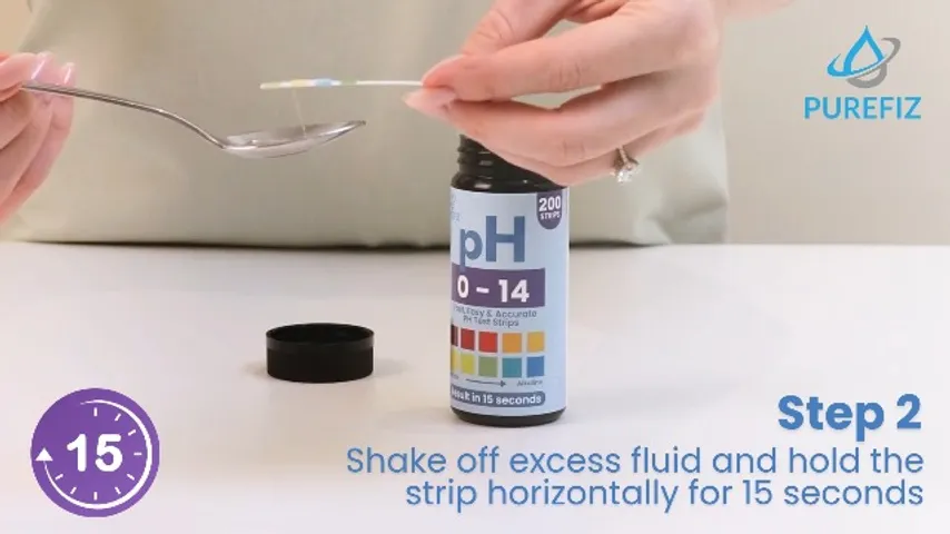 Step two of the pH strip demo — shaking off excess fluid before the 15-second hold