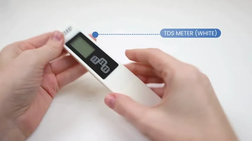 The white TDS pen meter held in hand