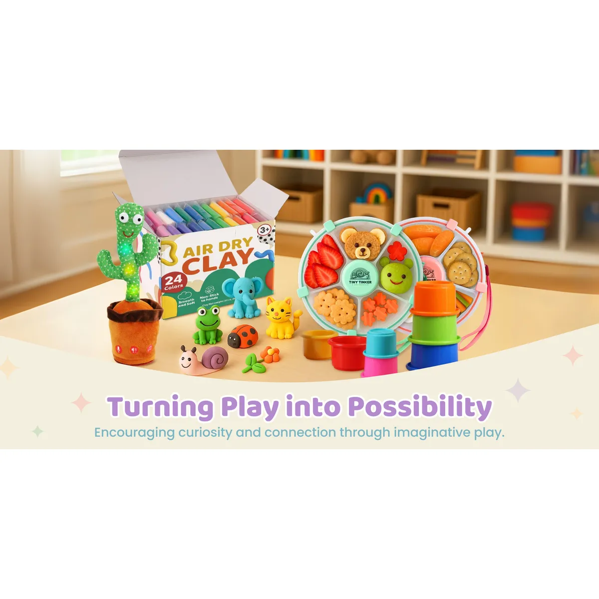 Playroom table with a talking cactus plush, an open air-dry clay box with clay animals, two filled snack boxes and stacking cups