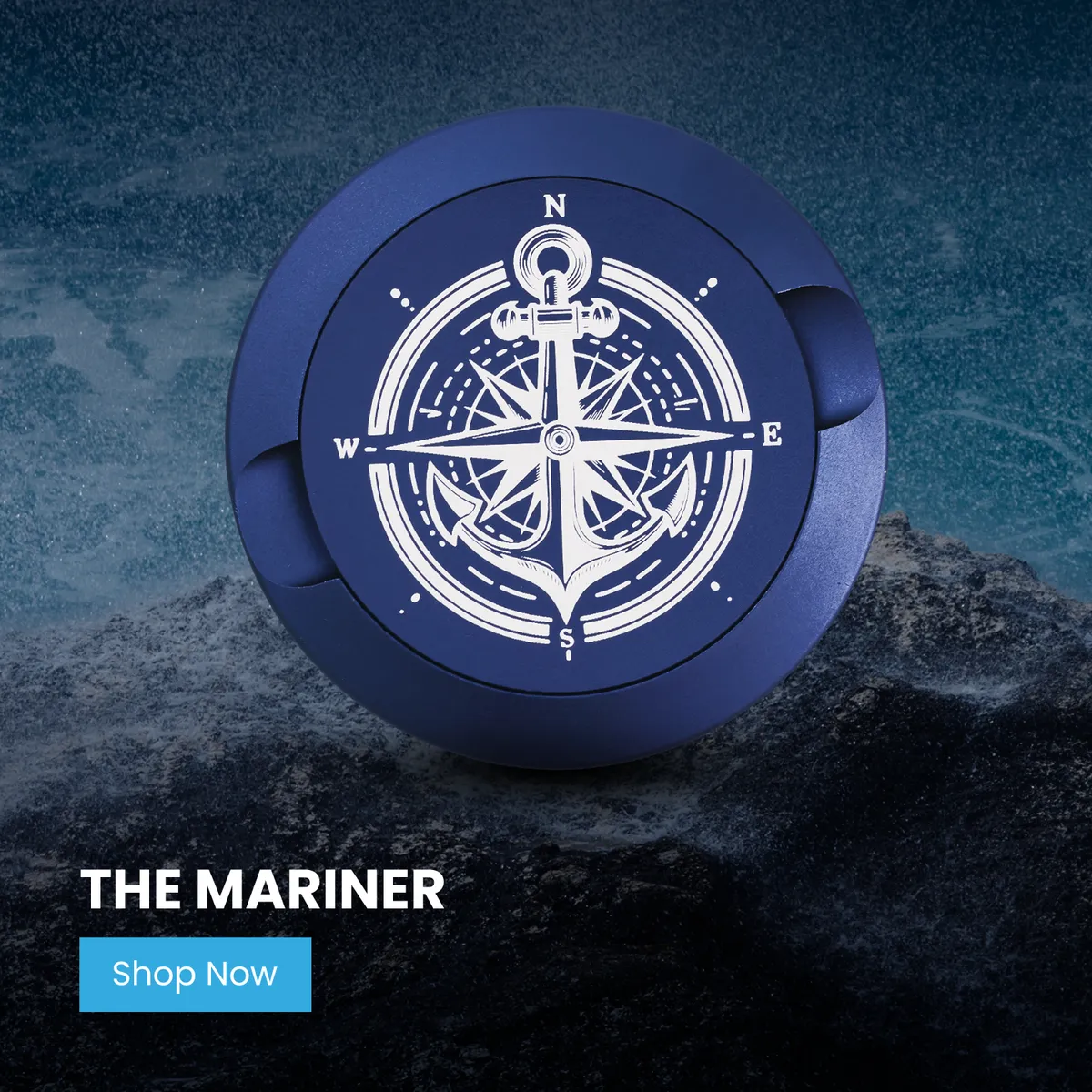 Navy blue metal can engraved with a compass rose and anchor, standing against a dark rocky ocean backdrop