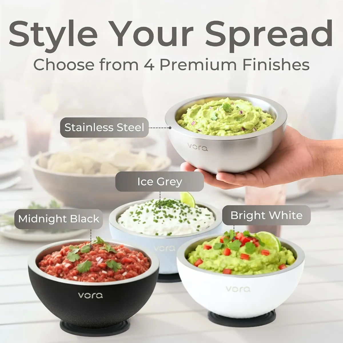 Hand holding a stainless steel Vora bowl of guacamole above bowls in Midnight Black, Ice Grey and Bright White finishes