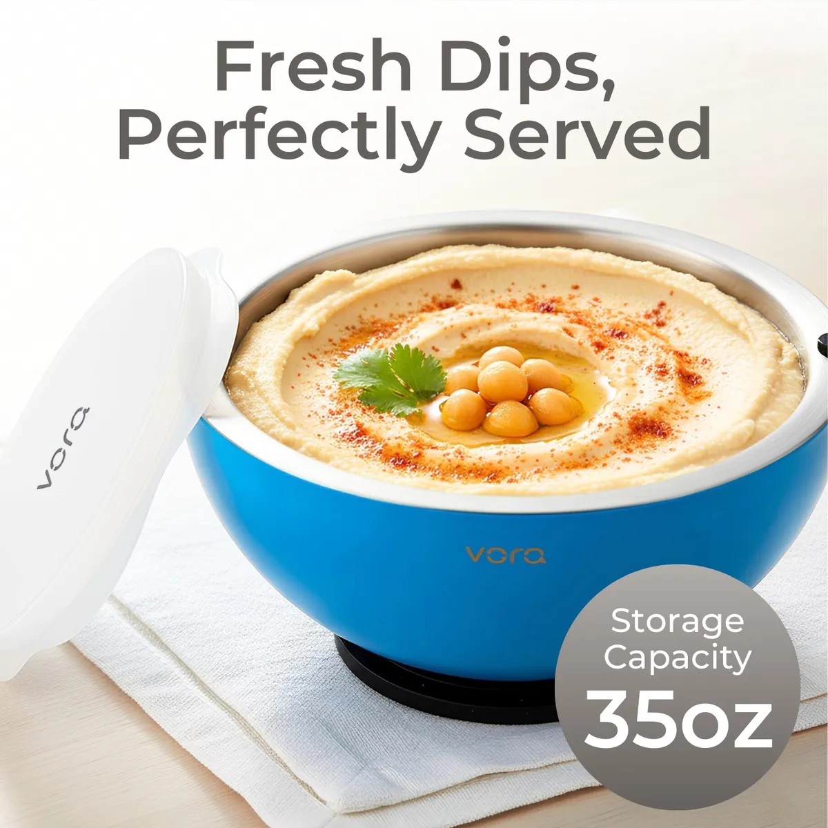 Blue 35oz Vora bowl of hummus swirled with paprika and chickpeas, with its white silicone lid leaning against the side