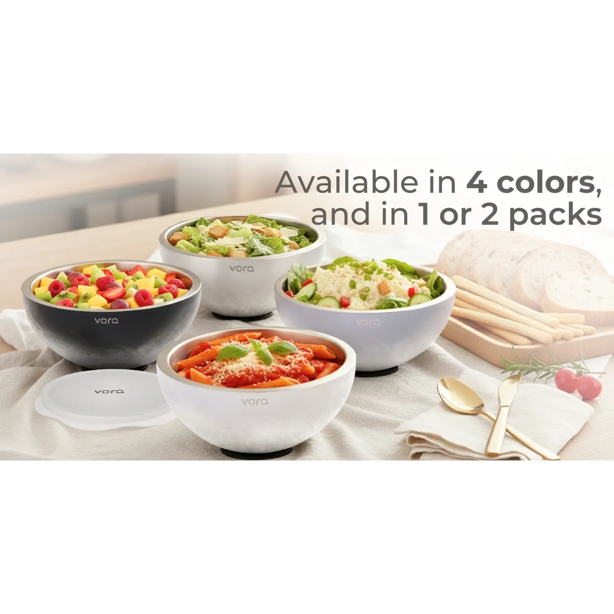 Four Vora bowls holding fruit salad, caesar salad, penne pasta and potato salad on a linen-covered table